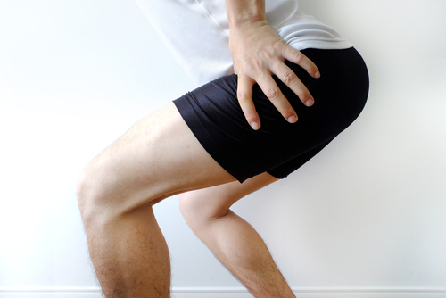 male athlete jogger wearing man runner massaging hip calf muscle before workout