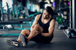 Man holding his knee in pain after sustaining a meniscus tear while exercising.