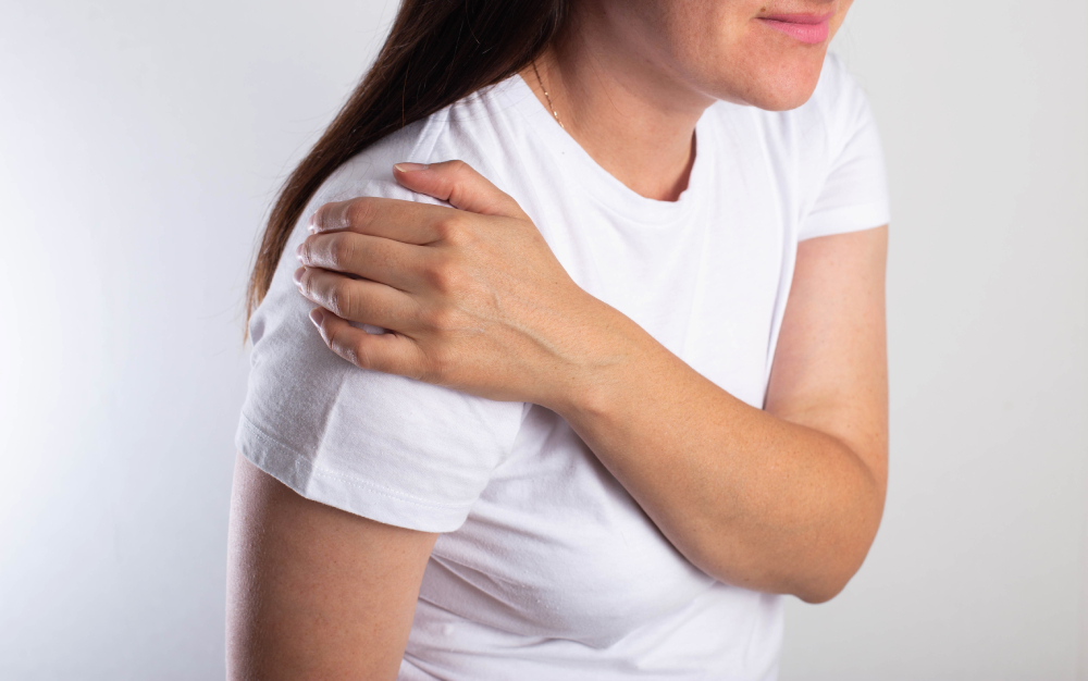 A cropped shot of a woman holding her shoulder because she needs shoulder surgery.